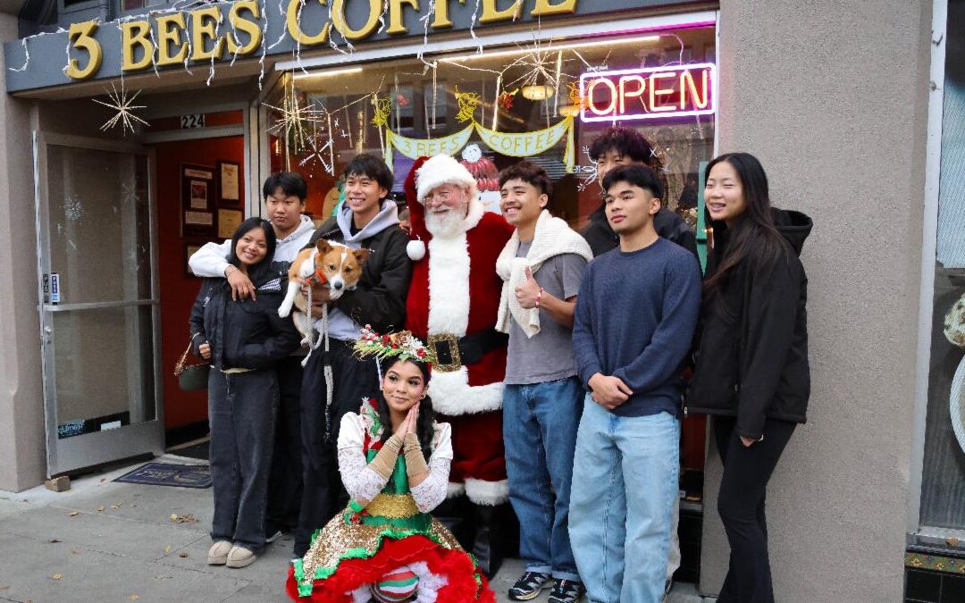 Photo of a family, Santa, and an elf posing in front of 3 Bees Coffee
