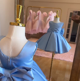 photo of the back of a blue child's dress and its reflection in the mirror
